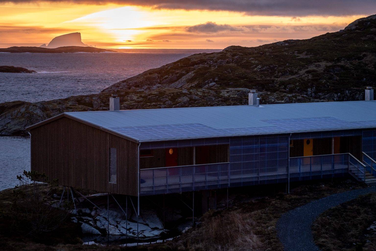 Bâtiment sur pilotis de Myken avec vue sur la mer au coucher du soleil