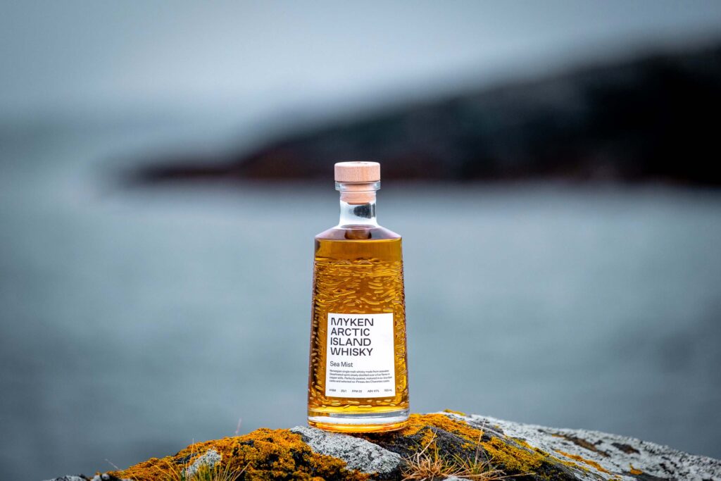 Bouteille de Myken Arctic Island Whisky Sea Mist sur un rocher au bord de la mer sur l’île de Myken en Norvège