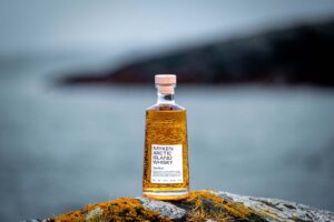 Bouteille de Myken Arctic Island Whisky Sea Mist sur un rocher au bord de la mer sur l’île de Myken en Norvège